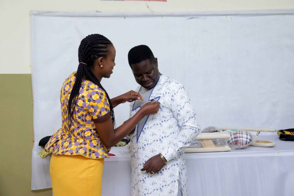 The benefactor decorating Dr. Owiah Sampson with her company’s customised lapel pin